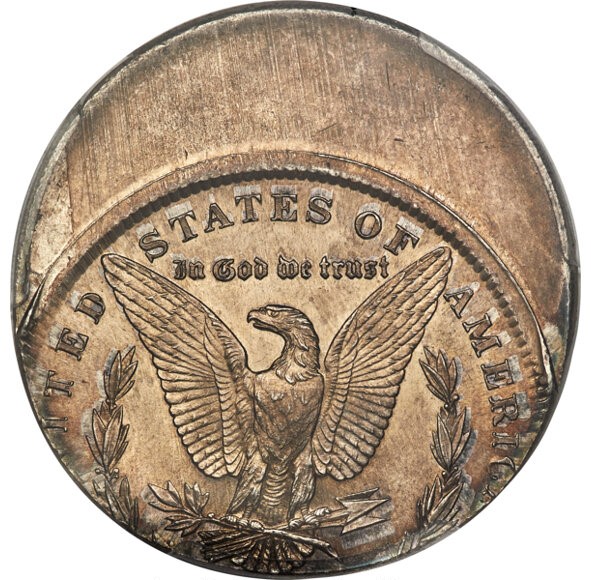 Off-center struck Morgan silver dollar showing partial design with visible date and mint mark